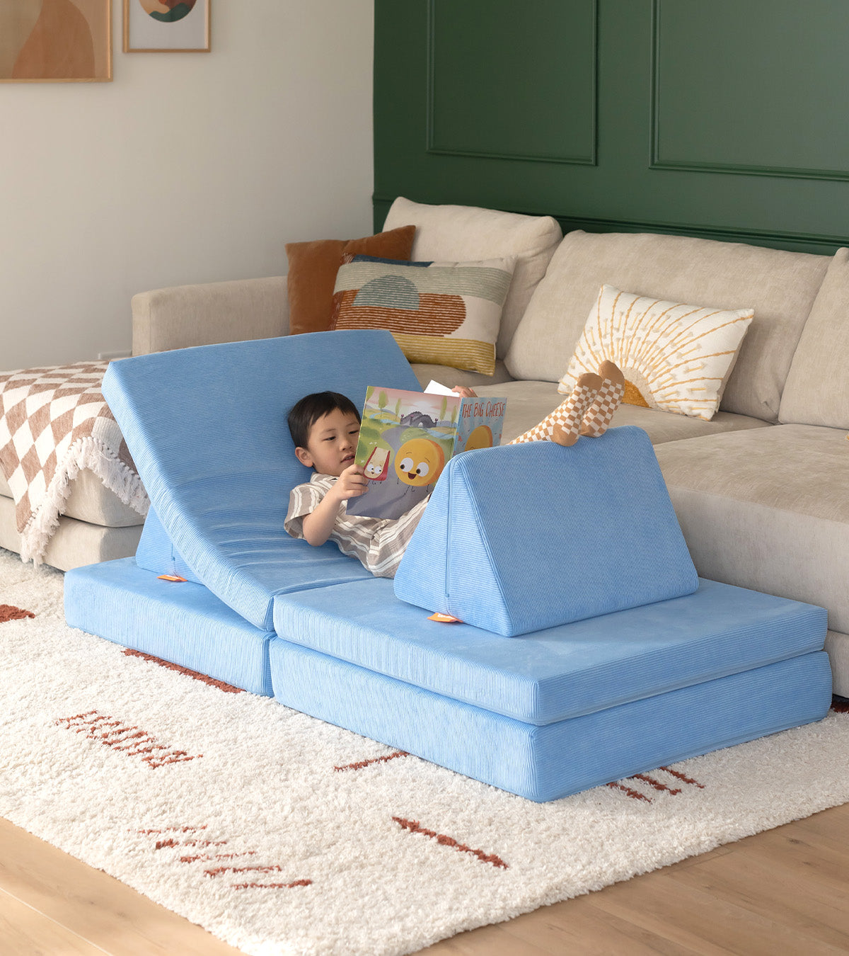 boy reading a book on a Bellbottom Nugget couch