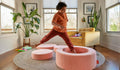 A child leaps into the hoop of a Blossom light pink Chunk play ottoman, set up as stepping stones.