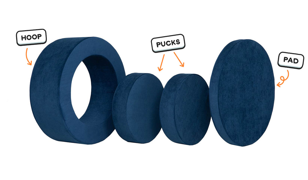 Four pieces of a navy blue Chunk play ottoman lined up: one large hoop, two sturdy nesting, and one wider pad for the lid.
