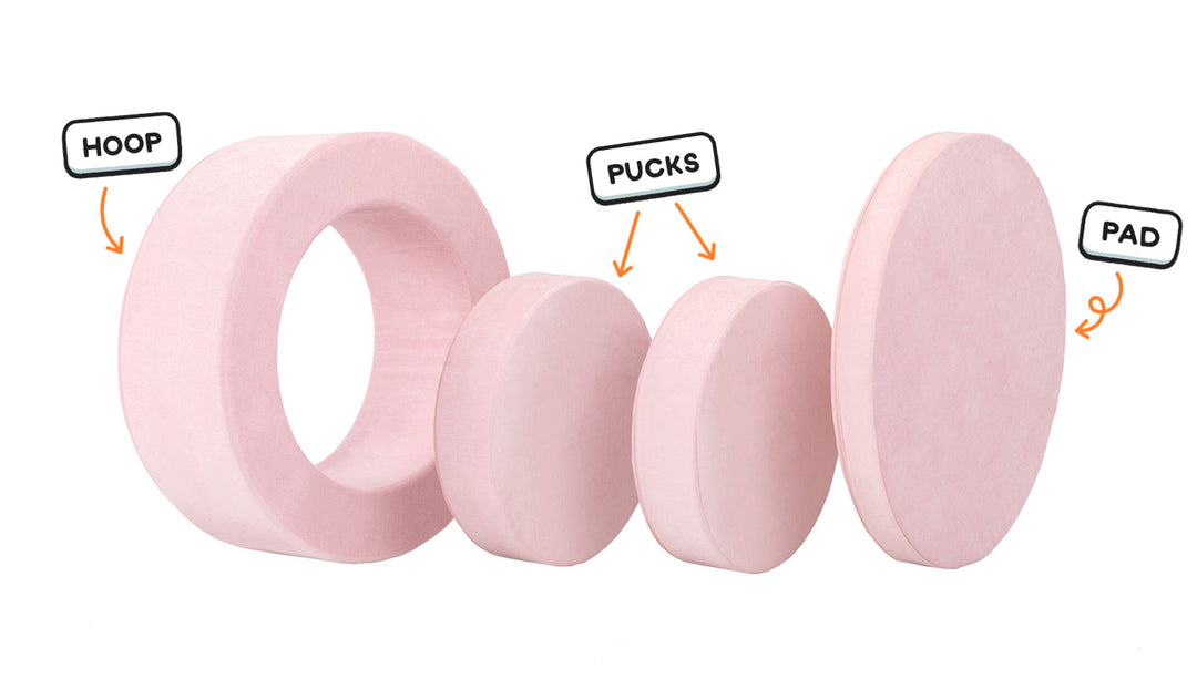 Four pieces of a blush pink Chunk play ottoman lined up: one large hoop, two sturdy nesting, and one wider pad for the lid.