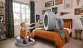 A child throws a ball through the hoop of a Koala light gray Chunk play ottoman.