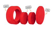 Four pieces of a true red Chunk play ottoman lined up: one large hoop, two sturdy nesting, and one wider pad for the lid.