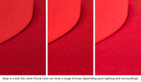 Close-up of a Chunk puck in Trolley true red across three lighting situations. One color can present as a range of tones depending on the room.