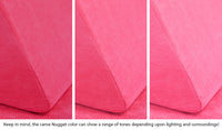 Close-up of a Nugget pillow in Popstar hot pink across three lighting situations. One color can present as a range of tones depending on the room.