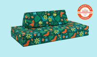 A lively dinosaur-patterned Nugget play couch set up in a kids' sofa configuration.