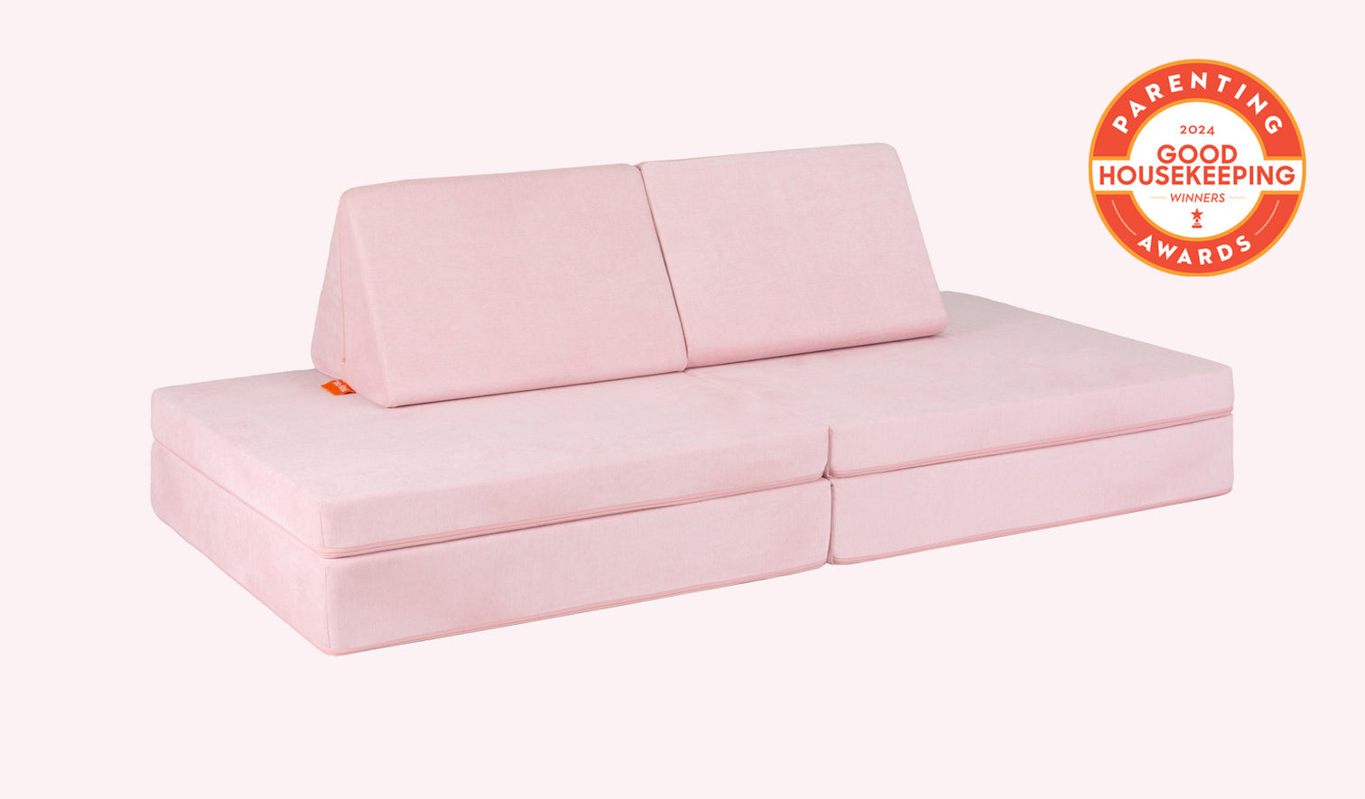 A Heartthrob blush pink Nugget play couch set up in a kids' sofa configuration.