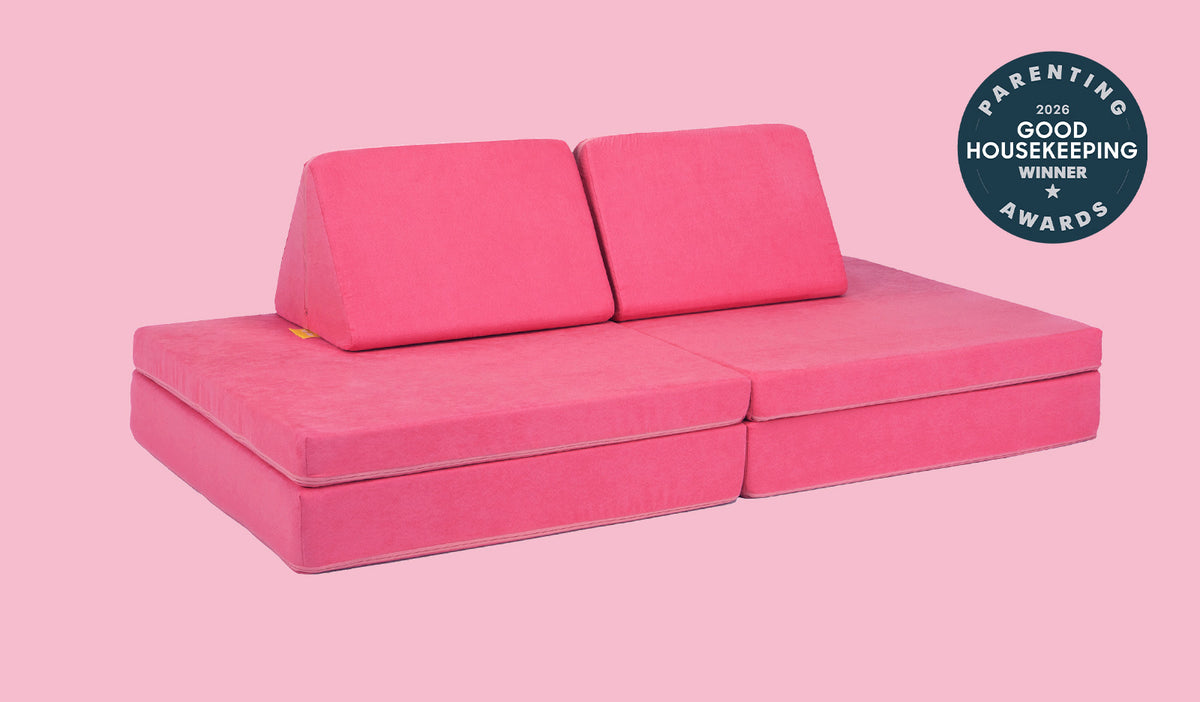 A Popstar hot pink Nugget play couch set up in a kids' sofa configuration.
