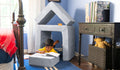 A child colors while relaxing in a small fort made from a light gray Smore play chair.