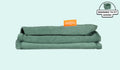 A neatly folded and stacked Smore Cover Set in sea green Seamonster.