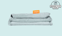 A neatly folded and stacked Smore Cover Set in light gray-blue Surfside.
