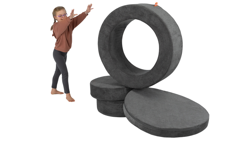 A child rolls the hoop of a dark gray storage ottoman, designed for functional usage and imaginative play.