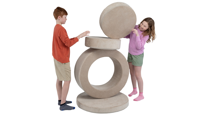 Two children balance the pieces of a neutral beige play ottoman, showing off all four pieces of this modular foam ottoman.