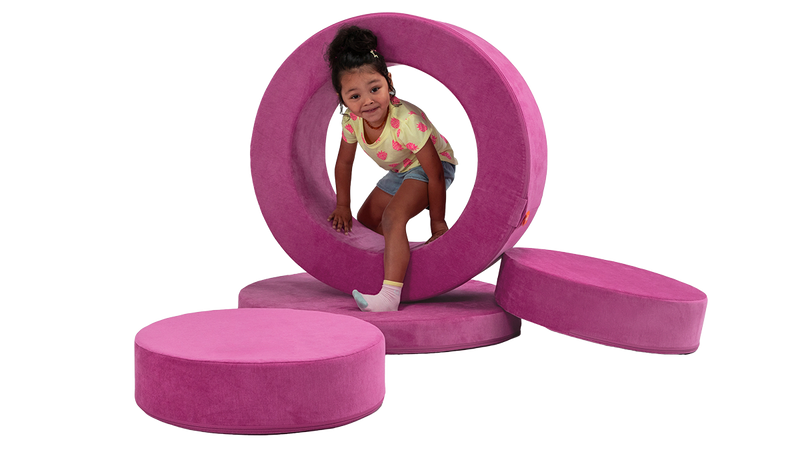 A child plays inside the hoop of a fuchsia storage ottoman, built for functional usage and imaginative play.
