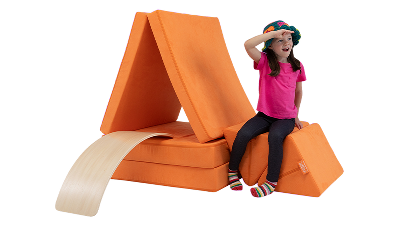 A child looks toward the horizon from a Nuggety sailboat build, created using one orange Nugget play couch.