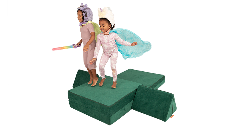 Two children in capes jump on a one-Nugget cliff build, ready for imaginative play with a Nugget play couch.