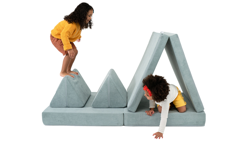 Two children play on an obstacle course made from one light blue Nugget play couch.