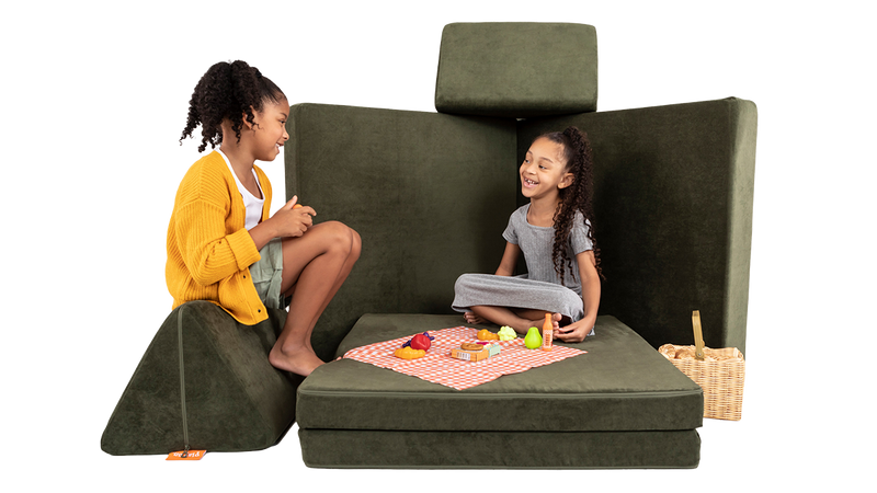 wo children share a Nuggety picnic lunch, across a picnic table build, created using one forest green Nugget play couch.