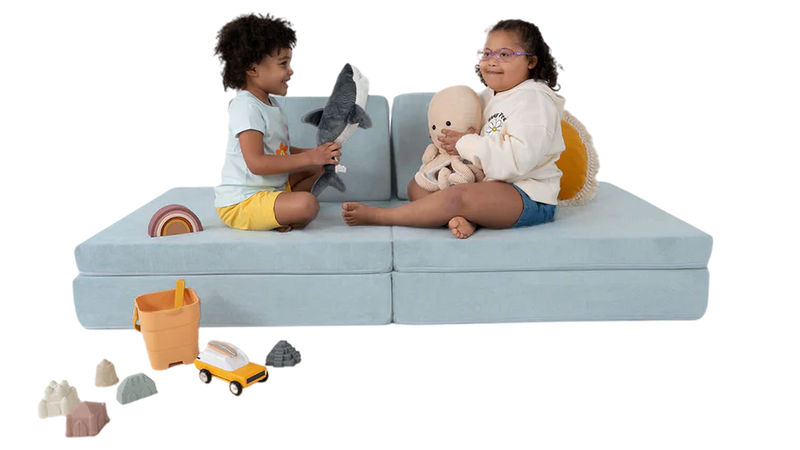 Two children cuddle with their stuffed animals and toys, relaxing in a one-Nugget couch build.