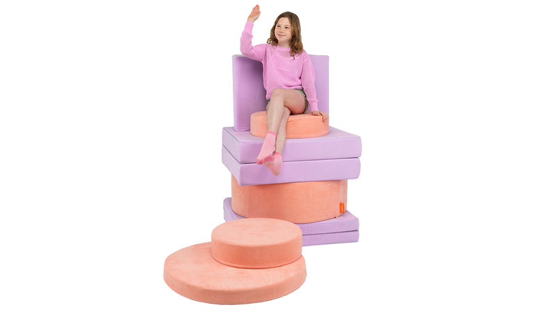 A child sits atop a colorful throne build, using one Nugget and one Chunk stacked up high.