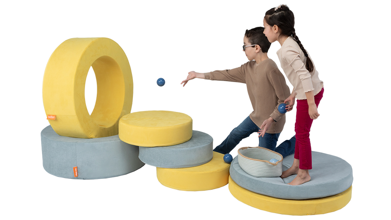Two children play with two Chunk play ottomans, using various pieces to create an arcade-style game.