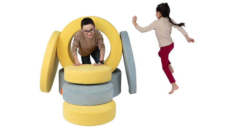 Two children take turns playing inside a portal constructed with two Chunk play ottomans.
