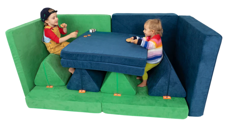 Two children have a snack at a diner booth build, constructed using two Nugget play couches.