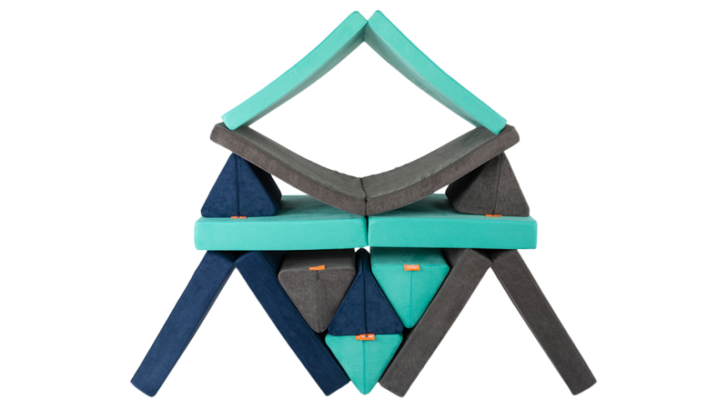 Three Nugget play couches form a colorful pyramid build, ready for creativity and open-ended play.