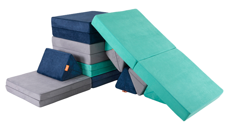 Three Nugget play couches are constructed into a tower with a cushion slide back down to the ground.