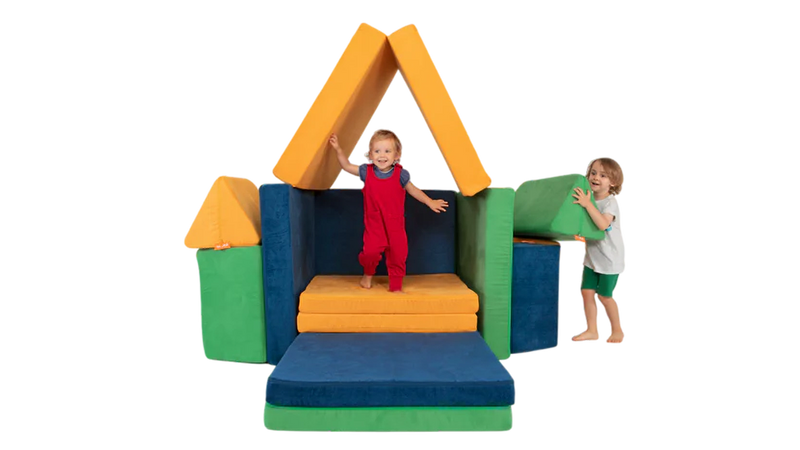 Two children play on a three-Nugget build resembling a colorful stage, built from three Nugget play couches.