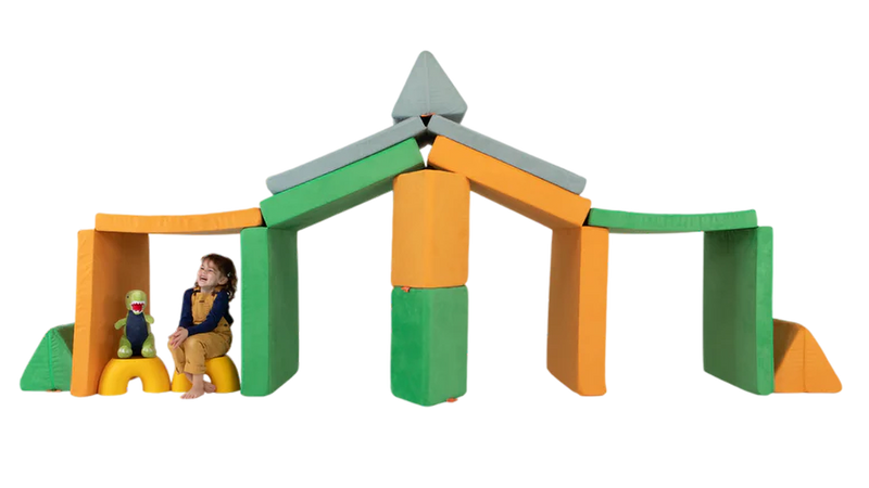 A child and her stuffed animal play in a three-Nugget build resembling a stable — ready for imaginative play.