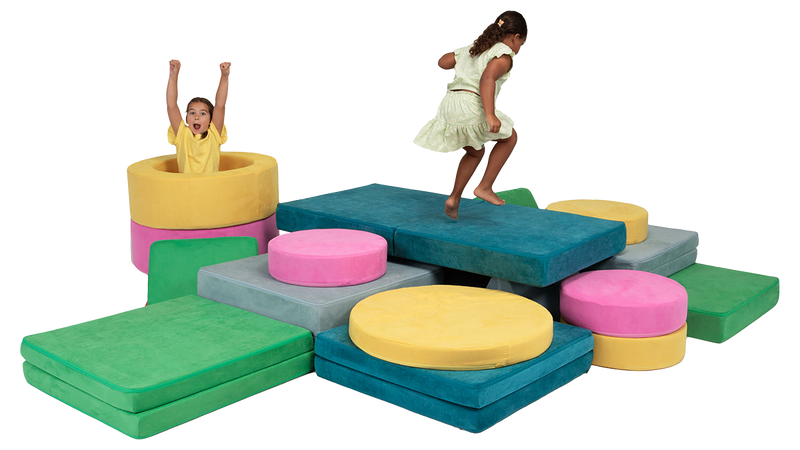 Two kids jump on a bright, colorful play furniture-build made from three Nugget play couches and two Chunk play ottomans.