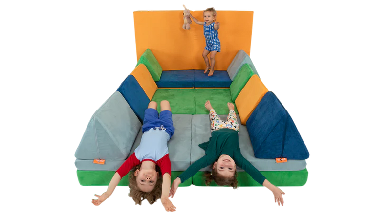Three children jump and roll on a four-Nugget build, showing play furniture imaginative open-ended play in action.