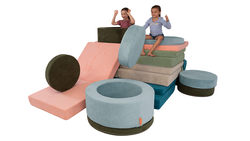 Two children play with an imaginative play fort built out of four stacked Nugget play couches and two Chunk play ottomans.