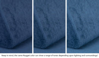 Close-up of a Nugget pillow in Blueridge navy blue across three lighting situations. One color can present as a range of tones depending on the room.