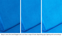 Close-up of a Nugget pillow in Neptune cobalt blue across three lighting situations. One color can present as a range of tones depending on the room.