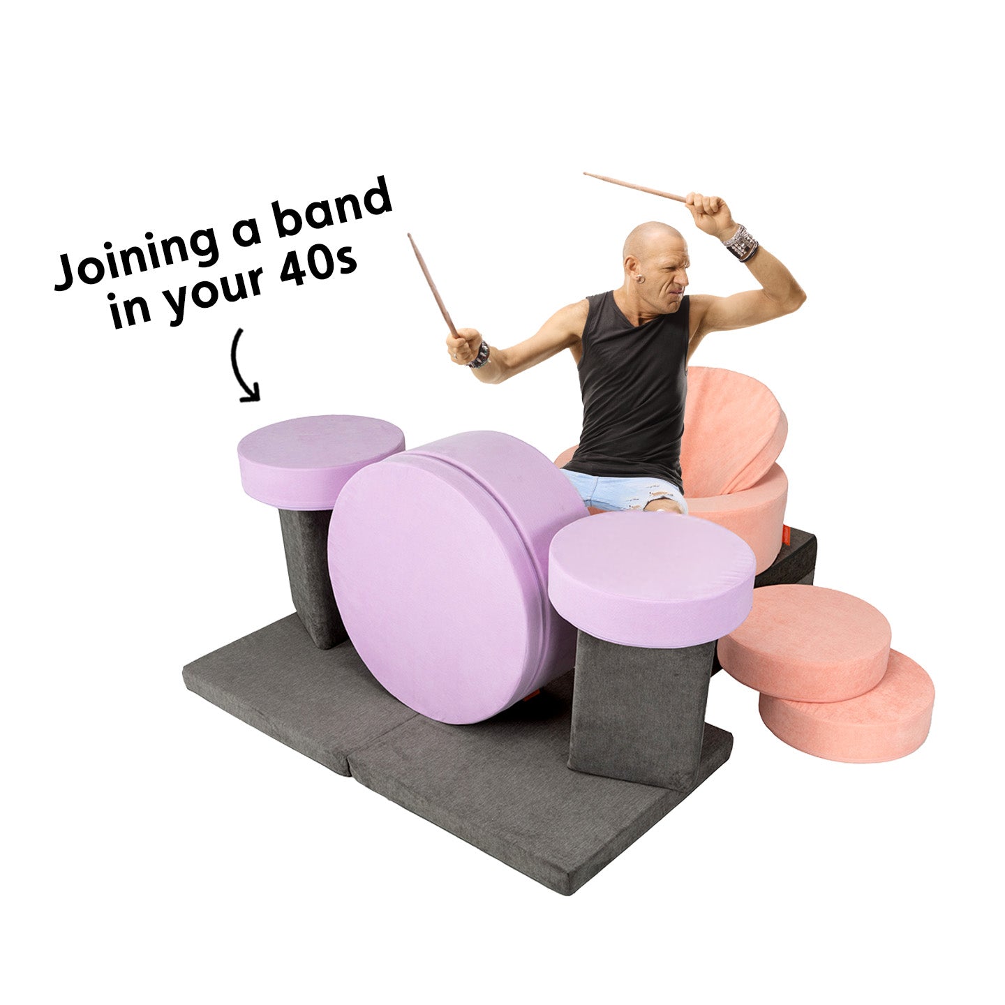 A man plays a pretend drumset made out of a Nugget and two Chunk play ottomans.