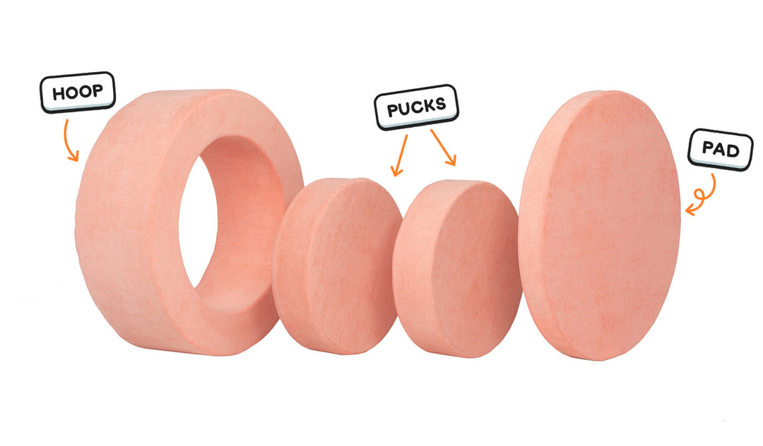 Four pieces of a light peach Chunk play ottoman lined up: one large hoop, two sturdy nesting, and one wider pad for the lid.