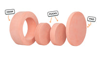 Four pieces of a light peach Chunk play ottoman lined up: one large hoop, two sturdy nesting, and one wider pad for the lid.