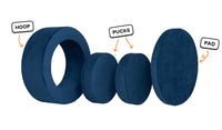 Four pieces of a navy blue Chunk play ottoman lined up: one large hoop, two sturdy nesting, and one wider pad for the lid.