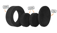 Four pieces of an all-black Chunk play ottoman lined up: one large hoop, two sturdy nesting, and one wider pad for the lid.