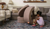 A child plays with a stuffed animal on a Cottontail earthy taupe Chunk play ottoman, set up on its side.