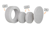 Four pieces of a light gray Chunk play ottoman lined up: one large hoop, two sturdy nesting, and one wider pad for the lid.