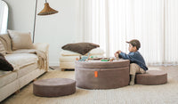 A child plays with blocks on top of a Kodiak earthy taupe Chunk play ottoman, set up as a table and chairs.