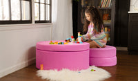 A child plays with Duplo blocks on top of a Lolly candy pink Chunk play ottoman, set up as a table and chair.