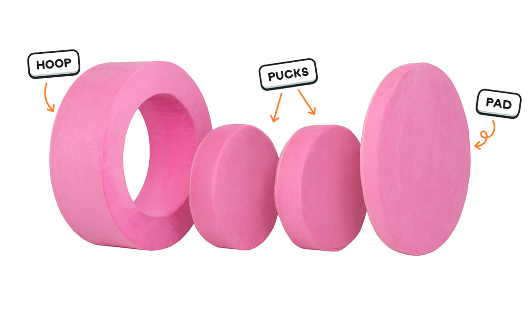 Four pieces of a candy pink Chunk play ottoman lined up: one large hoop, two sturdy nesting, and one wider pad for the lid.