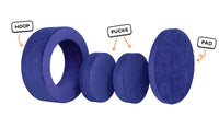 Four pieces of a vibrant indigo Chunk play ottoman lined up: one large hoop, two sturdy nesting, and one wider pad for the lid.