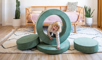 A child crawls through the hoop of a Seamonster sea green Chunk play ottoman.