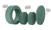 Four pieces of a sea green Chunk play ottoman lined up: one large hoop, two sturdy nesting, and one wider pad for the lid.