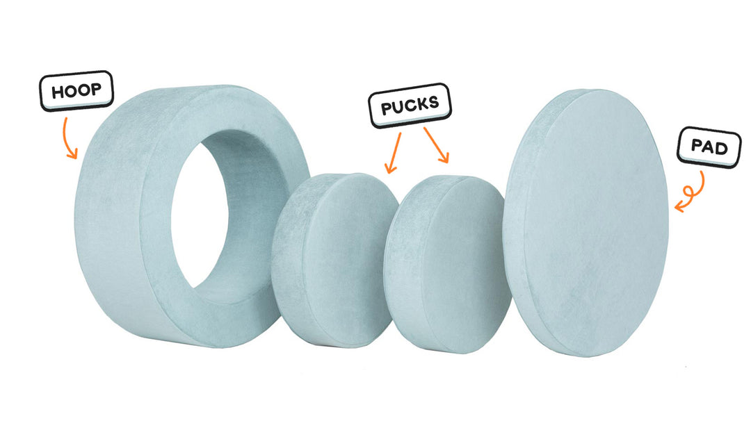 Four pieces of a light gray-blue Chunk play ottoman lined up: one large hoop, two sturdy nesting, and one wider pad for the lid.
