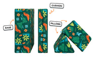 Four pieces of a dinosaur-patterned Nugget play couch lined up: one foldable base, one foldable cushion, and two triangular pillows.